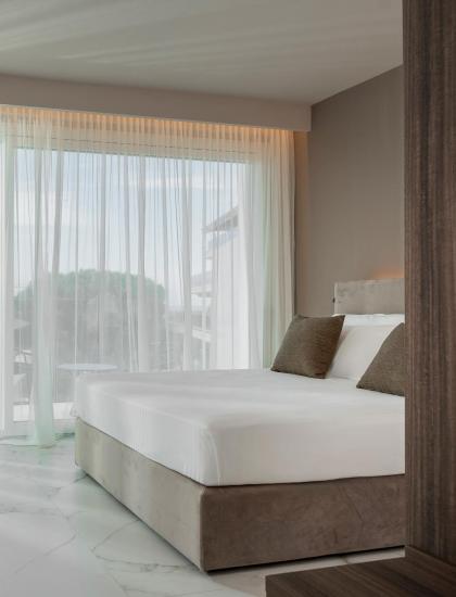 Camera moderna con letto e grandi finestre.