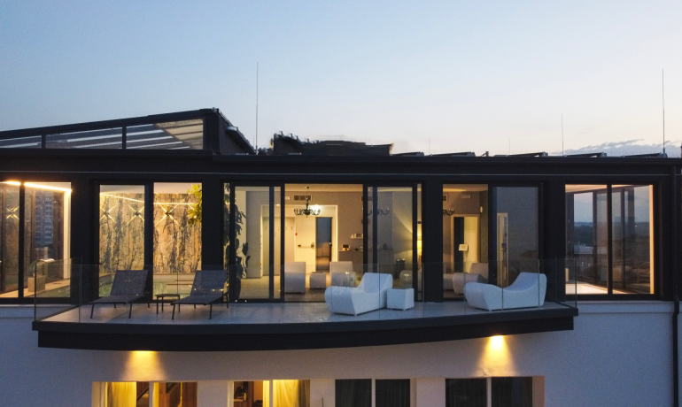 Moderno attico con ampie vetrate e terrazza panoramica.