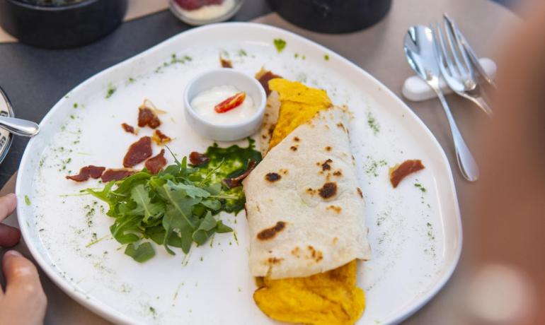 Delizioso brunch con wrap, dolci e salse, un'esperienza culinaria invitante.