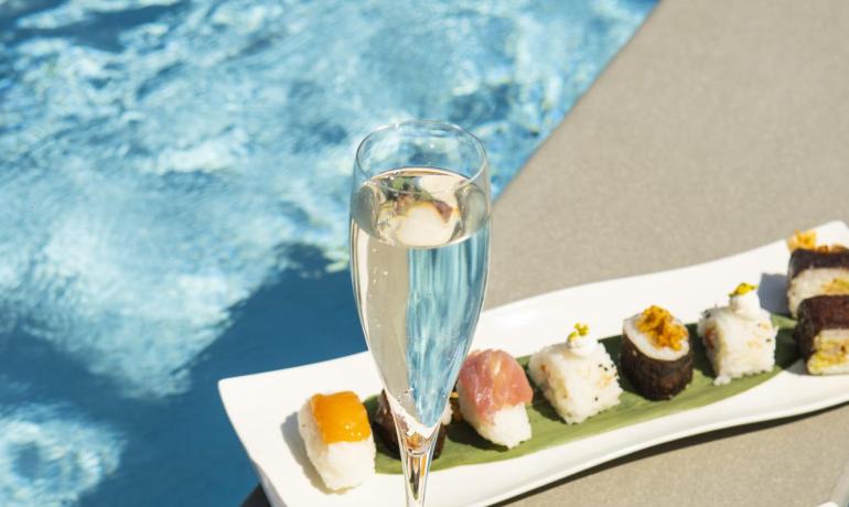 Sushi élégant et champagne au bord de la piscine, ambiance luxueuse et détendue.