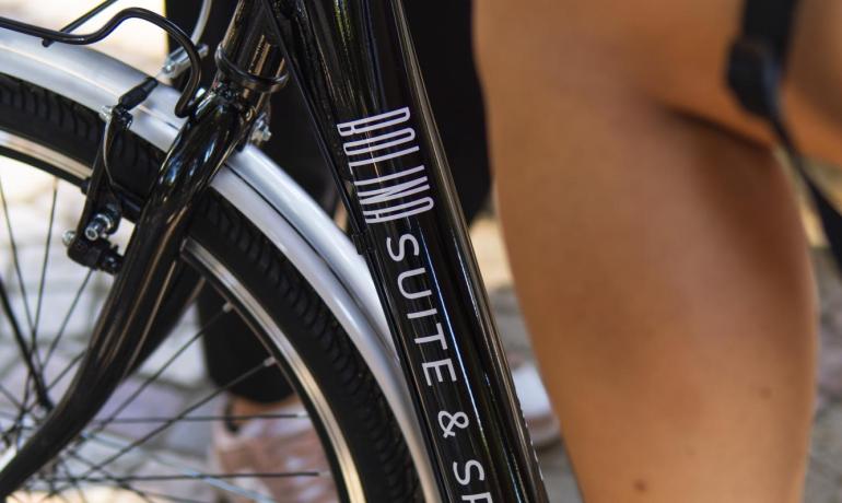 Bicicletta elegante, piedi in sandali neri, atmosfera rilassante e estiva.