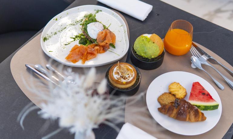 Colazione elegante: salmone, uovo, dolci, frutta e succo d'arancia.