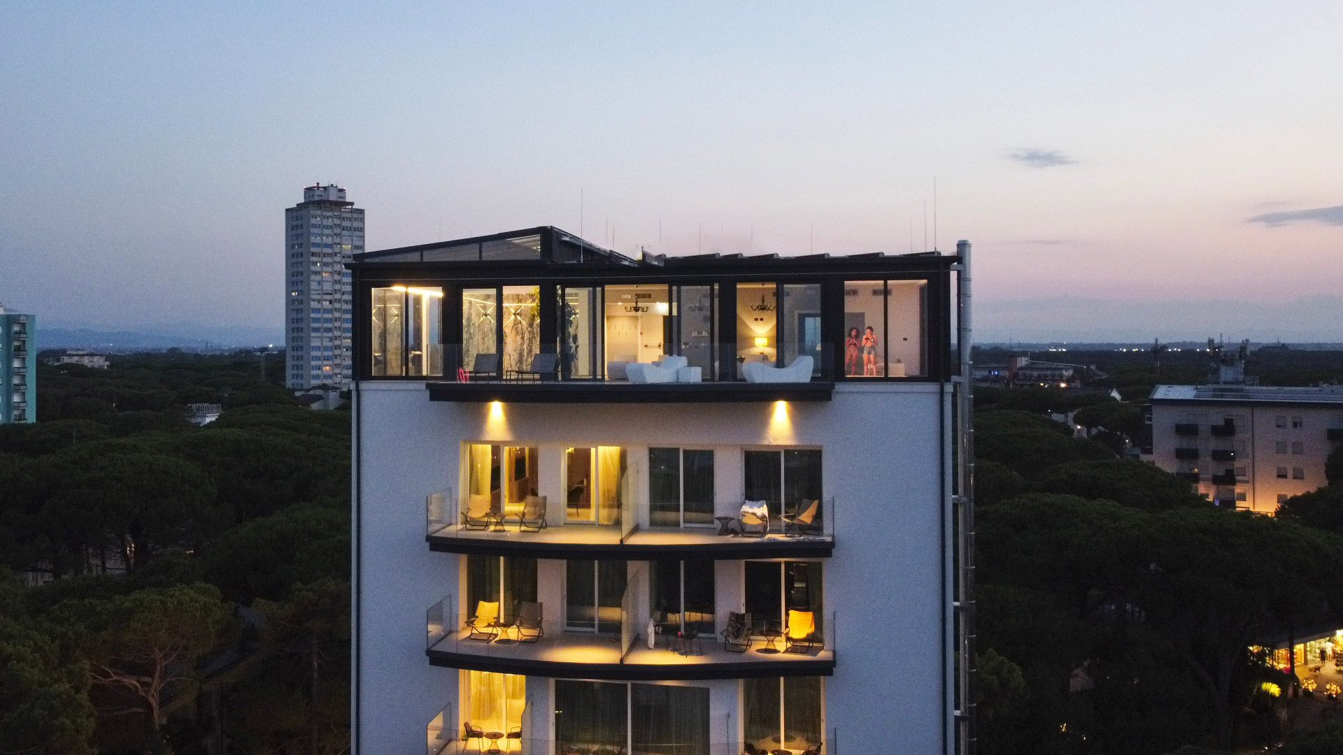 Tramonto su attico moderno, luci calde, vista panoramica, atmosfera elegante e rilassante.