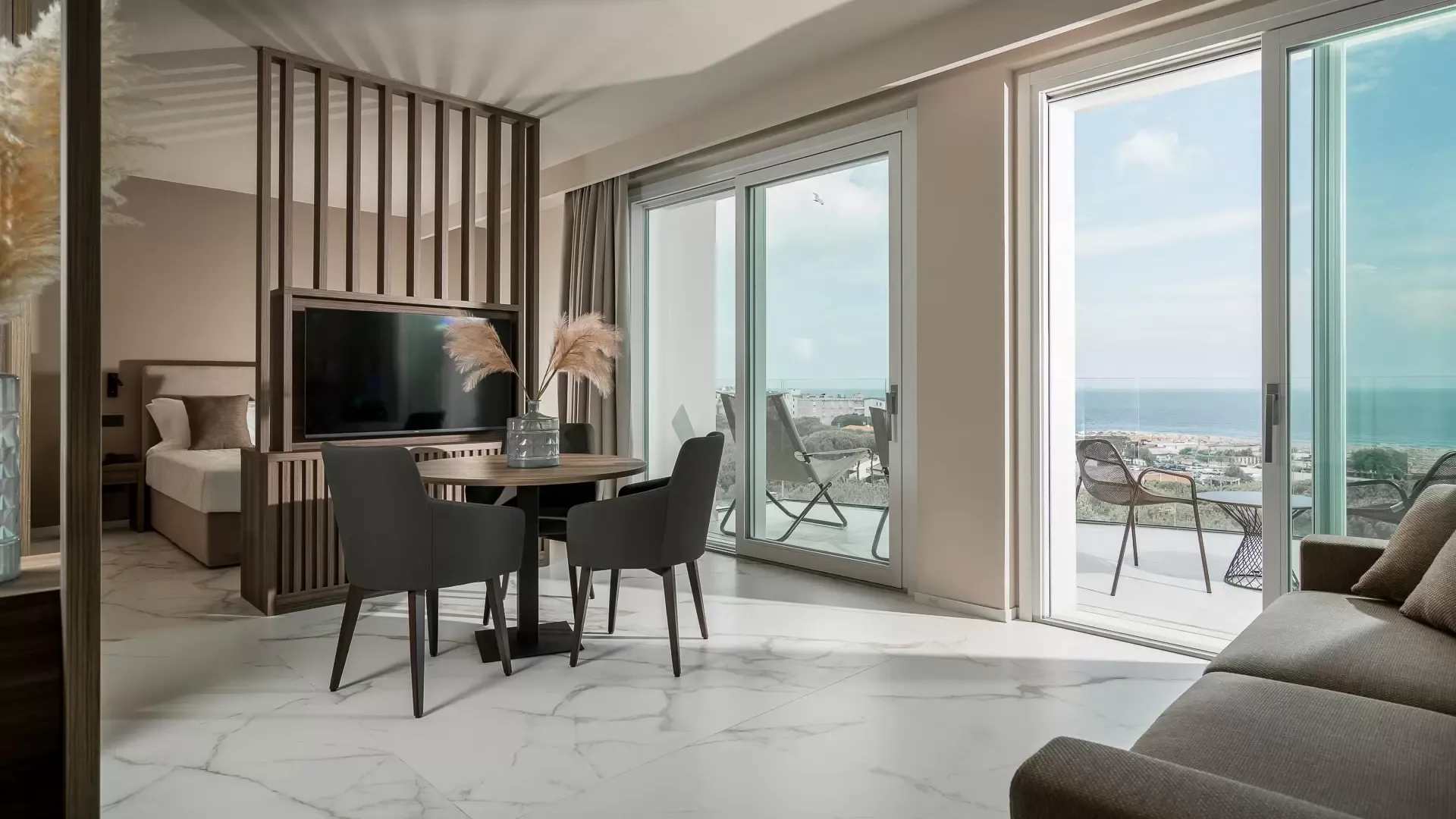 Moderno soggiorno con vista mare, arredamento elegante e pavimento in marmo bianco.