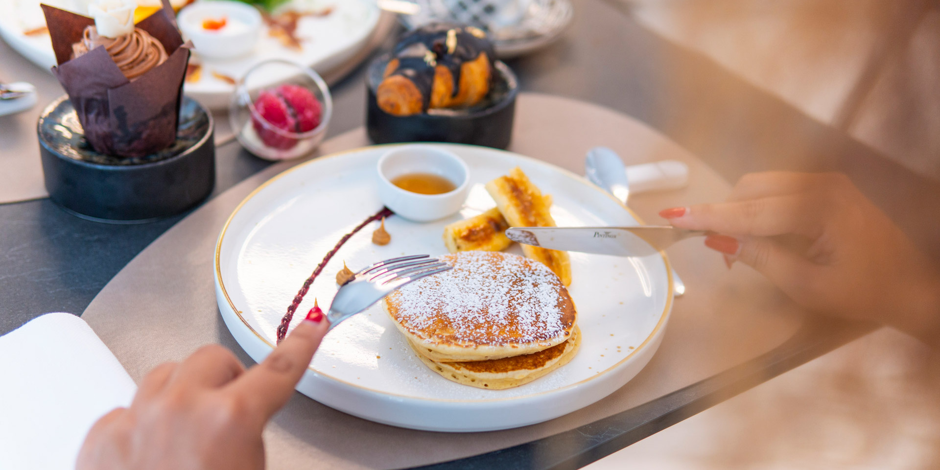 Colazione elegante: pancake soffici, croissant, muffin e frutta, un'esperienza dolce e raffinata.
