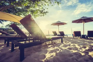 Spiaggia con lettini e ombrelloni al tramonto, atmosfera rilassante e tranquilla.
