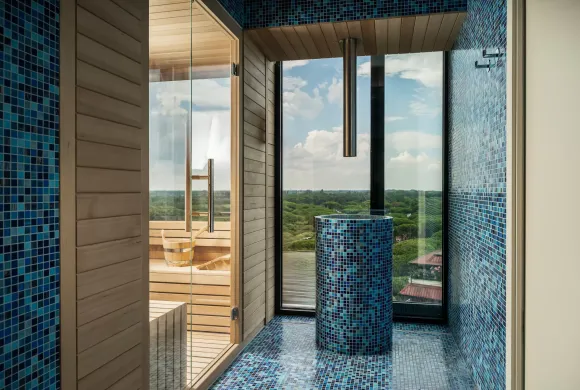 Sauna moderna con vista panoramica e rivestimenti a mosaico blu.