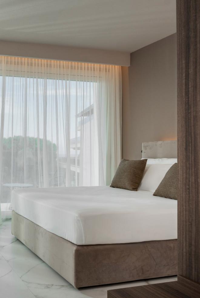 Camera luminosa con letto accogliente, tende leggere e atmosfera serena e rilassante.