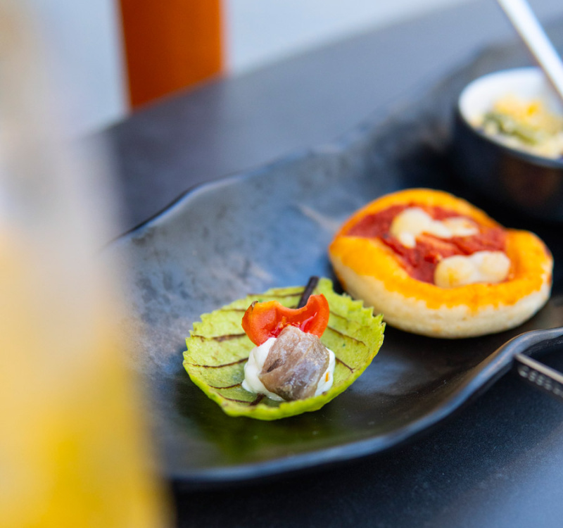 Sfiziosi finger food su piatto nero: sapori invitanti e colori vivaci.