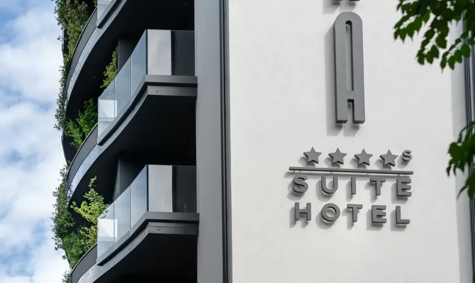 Hotel moderno con balconi verdi e insegna a cinque stelle.