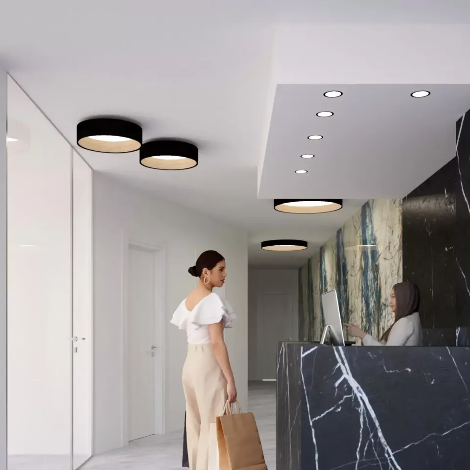 Reception moderna con pareti marmoree e illuminazione elegante, donna con borse.