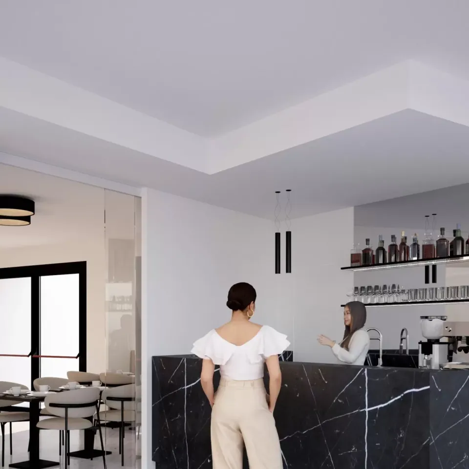 Interno di un bar moderno con bancone in marmo e due persone conversano.